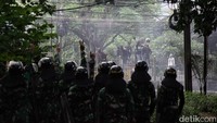 Polisi tampak menghampiri massa. Saat itu massa berlarian ke arah rel kereta.