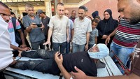 Fotografer Hatem Khaled, seorang kontraktor Reuters, dibantu setelah terluka dalam serangan Israel di Rumah Sakit Nasser. Serikat Jurnalis Palestina mengecam Israel atas serangan tersebut, dengan mengatakan bahwa Israel merupakan perang terbuka terhadap media bebas, dengan tujuan meneror jurnalis dan mencegah mereka memenuhi tugas profesional mereka untuk mengungkap kejahatan Israel kepada dunia. Foto: REUTERS/Ramadan Abed