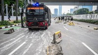 Kendaraan taktis melintasi kawasan Gedung DPR, pembatas jalur Transjakarta tampak rusak berserakan di jalan. Foto: ANTARA FOTO/Rivan Awal Lingga