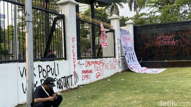 Sejumlah orang demonstrasi di gerbang belakang gedung MPR/DPR, Jakarta. Tembok gerbang belakang gedung MPR/DPR menjadi sasaran vandalisme. (Devi P/detikcom)