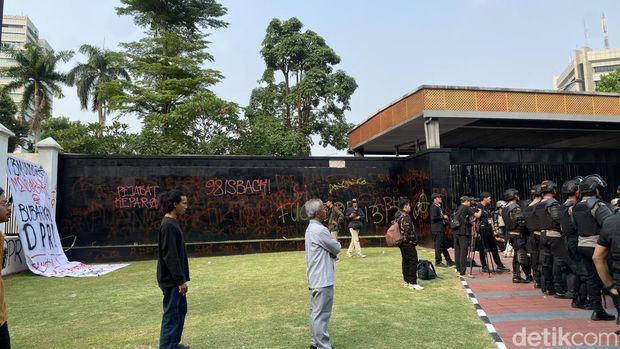 Sejumlah orang demonstrasi di gerbang belakang gedung MPR/DPR, Jakarta. Tembok gerbang belakang gedung MPR/DPR menjadi sasaran vandalisme. (Devi P/detikcom)