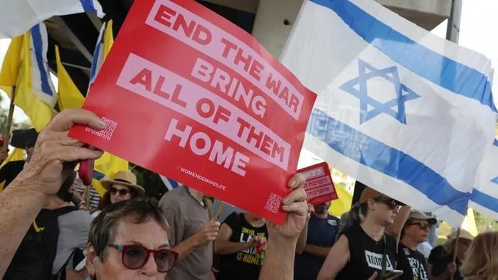 Protesters gather with signs and Israeli flags in Tel Aviv on August 26, 2025. (AFP)