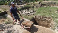Petugas membawa batu bata untuk dibersihkan saat ekskavasi di Situs Tondowongso, Desa Gayam, Kabupaten Kediri, Jawa Timur. Foto: ANTARA FOTO/Prasetia Fauzani
