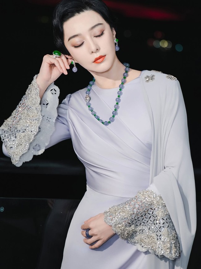 Busana bernuansa lavender hadir dengan detail drapery di bagian dada dan hiasan kristal di ujung lengan dan pinggiran hem. Busana tersebut merupakan karya desainer Fiziwoo. Foto: Instagram/@bingbing_fan @fiziwoo