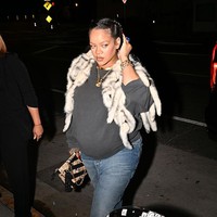 Dengan gaya kasual malam hari, Rihanna memilih sweater abu-abu dan jeans cut flare. Ia melapisi dengan rompi bulu bernuansa krem, menambahkan sentuhan glam lewat tas print monogram dan aksesori emas. (Foto: DUTCH/Bauer-Griffin/GC Images)