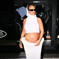 Sang bintang tampil futuristis dalam setelan serba putih dari Alaia. Rihanna mengenakan crop top sleeveless dengan penutup kepala terintegrasi, memamerkan baby bump dalam rok panjang tekstur glitter. Kacamata hitam ramping melengkapi gaya bold nan edgy. (Foto: DUTCH/Bauer-Griffin/GC Images)