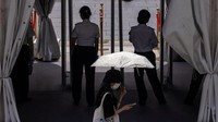 Seorang perempuan tampak melewati pos pemeriksaan di pintu masuk pusat bisnis Beijing dengan payung di tangan. REUTERS/Maxim Shemetov