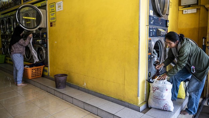 Sejumlah warga menunggu cuciannya di salah satu usaha cuci pakaian di Semarang, Jawa Tengah, Selasa (26/8/2025). Kementerian UMKM mendukung industri jasa penatu atau laundry untuk meningkatkan daya saing, salah satunya melalui program Sekolah Bisnis Laundry (SBL) sehingga mampu menjadi bidang jasa layanan yang strategis dan memberikan kontribusi signifikan bagi perekonomian nasional, karena terbukti telah menyerap lebih dari 34 ribu tenaga kerja, baik pada sektor formal maupun informal. ANTARA FOTO/Aprillio Akbar