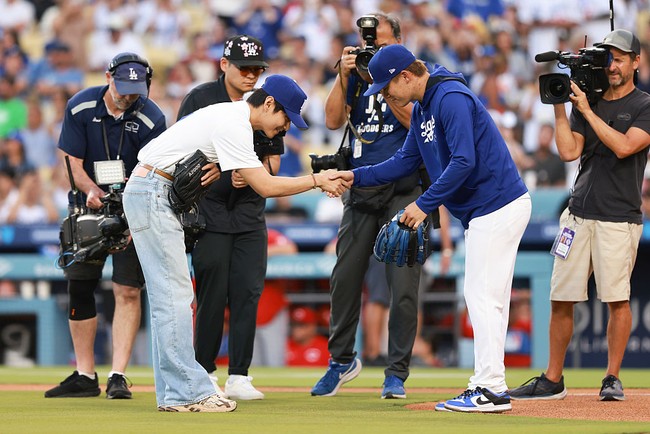 Lemparan V BTS berhasil ditangkap sempurna oleh Yoshinobu Yamamoto, pitcher Dodgers. Aksinya menjadi pembuka pertandingan yang menggugah atmosfer stadion, diiringi lagu Mic Drop. Foto: Getty Images