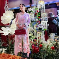 Gaya Bebizie saat kondangan dengan gaya tradisional. Ia tampak memadukan kebaya modern pink-nya dengan Hermes Kelly Cut Sanguine Swift Palladium Hardware yang ditentengnya. Diperkirakan harga clutch merah yang dibawanya itu mencapai sekitar Rp 262 juta. Foto: Instagram/@bebizie