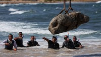 Tim arkeolog Mesir mengevakuasi artefak kuno yang ditemukan di perairan pesisir Alexandria pada Kamis (21/8/2025). REUTERS/Amr Abdallah Dalsh