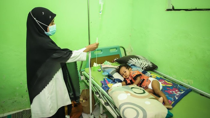 Petugas kesehatan Puskesmas Pragaan memeriksa pasien campak di Pragaan, Sumenep, Jawa Timur, Rabu (27/8/2025). Kementerian Kesehatan (Kemenkes) mencatat, sejak awal tahun hingga pekan ketiga Agustus 2025 terdapat 46 Kejadian Luar Biasa (KLB) campak di 42 kabupaten/kota dengan total 3.144 kasus positif dimana 2.139 kasus diantaranya terjadi di Sumenep yang menyebabkan 17 penderita meninggal dunia dan menjadi kasus tertinggi nasional. ANTARA FOTO/Rizal Hanafi/bar