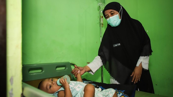 Petugas kesehatan Puskesmas Pragaan memeriksa pasien campak di Pragaan, Sumenep, Jawa Timur, Rabu (27/8/2025). Kementerian Kesehatan (Kemenkes) mencatat, sejak awal tahun hingga pekan ketiga Agustus 2025 terdapat 46 Kejadian Luar Biasa (KLB) campak di 42 kabupaten/kota dengan total 3.144 kasus positif dimana 2.139 kasus diantaranya terjadi di Sumenep yang menyebabkan 17 penderita meninggal dunia dan menjadi kasus tertinggi nasional. ANTARA FOTO/Rizal Hanafi/bar