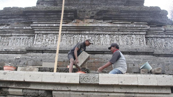 Pemugaran Candi Jago, Terungkap Struktur Bata Kuno Era Majapahit Pekerja memotong batuan pengganti sebelum dipasang saat pemugaran Candi Jago, Tumpang, Malang, Jawa Timur, Rabu (27/8/2025). Pemugaran Candi peninggalan Kerajaan Singhasari abad ke-13 yang dilakukan Balai Pelestarian Kebudayaan (BPK) XI Jawa Timur tersebut memasuki tahap pemasangan kembali batur atau kaki candi yang mengalami pelapukan dan dalam prosesnya ditemukan struktur batu bata kuno yang diduga berasal dari era Majapahit akhir. ANTARA FOTO/Ari Bowo Sucipto