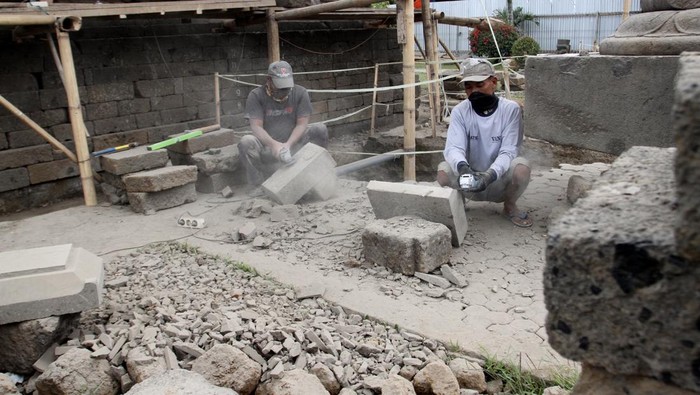 Pemugaran Candi Jago, Terungkap Struktur Bata Kuno Era Majapahit Pekerja memotong batuan pengganti sebelum dipasang saat pemugaran Candi Jago, Tumpang, Malang, Jawa Timur, Rabu (27/8/2025). Pemugaran Candi peninggalan Kerajaan Singhasari abad ke-13 yang dilakukan Balai Pelestarian Kebudayaan (BPK) XI Jawa Timur tersebut memasuki tahap pemasangan kembali batur atau kaki candi yang mengalami pelapukan dan dalam prosesnya ditemukan struktur batu bata kuno yang diduga berasal dari era Majapahit akhir. ANTARA FOTO/Ari Bowo Sucipto