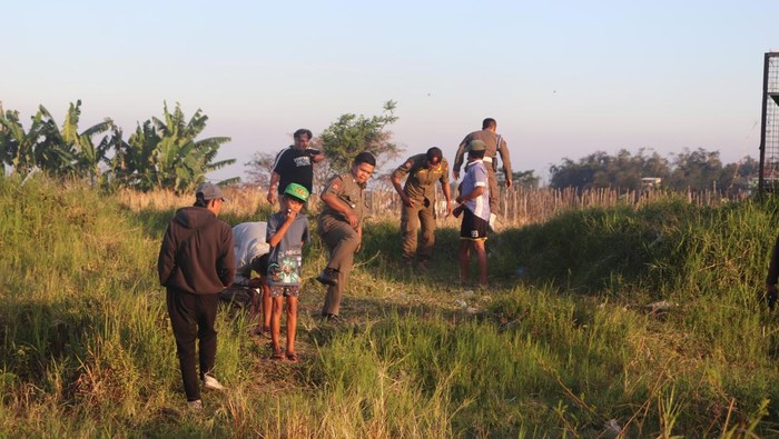 Petugas Satpol PP Kota Batu memberikan peringatan kepada masyarakat yang bermain layangan