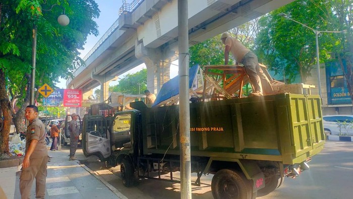 Petugas Satpol PP Palembang menertibkan lapak pedagang di atas trotoar Pasar Cinde