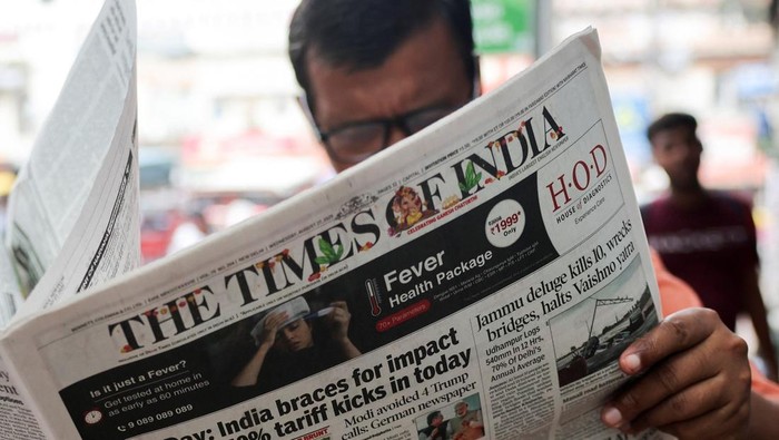 Trump Kenakan Tarif 50% ke India A man reads the latest edition of The Times of India newspaper, with the lead story on U.S. tariffs on most Indian goods, in the old quarters of Delhi, India, August 27, 2025. REUTERS/Anushree Fadnavis