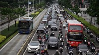 Pengendara motor dan mobil melintas perlahan di Jalan Sudirman, Jakarta, Kamis (28/9/2025). Suasana sore dipadati arus pulang kerja.