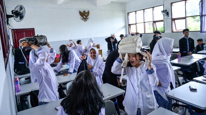Belajar Siaga Bencana, Siswa Bandung Ikuti Simulasi Gempa Bumi Siswa melindungi diri dengan kursi saat mengikuti simulasi penanganan gempa bumi di SMPN 1, Bandung, Jawa Barat, Kamis (28/8/2025). Pemerintah Kota Bandung melalui BPBD menggelar simulasi tanggap bencana gempa bumi yang ditujukan untuk melatih murid dalam mitigasi bencana alam secara mandiri terkait potensi gempa bumi akibat pergerakan Sesar Lembang di Kota Bandung. ANTARA FOTO/Raisan Al Farisi
