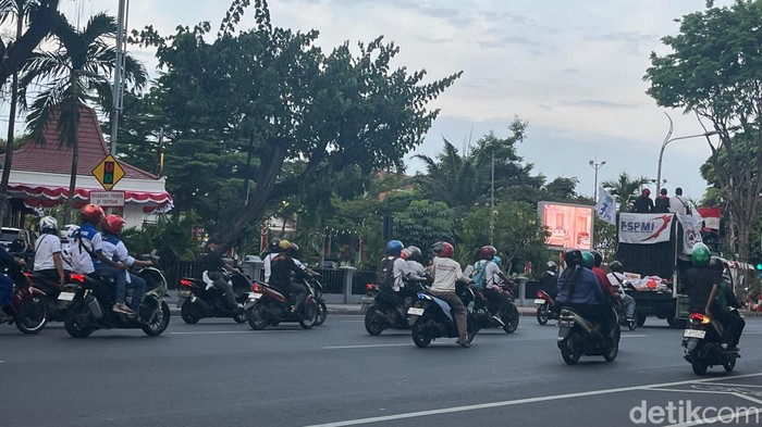 Buruh melintasi kawasan Gubernur Suryo usai mengikuti aksi unjuk rasa di depan Kantor Gubernur Jatim