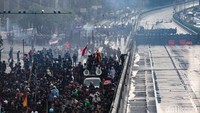 Polisi menembakkan gas air mata ke arah massa.