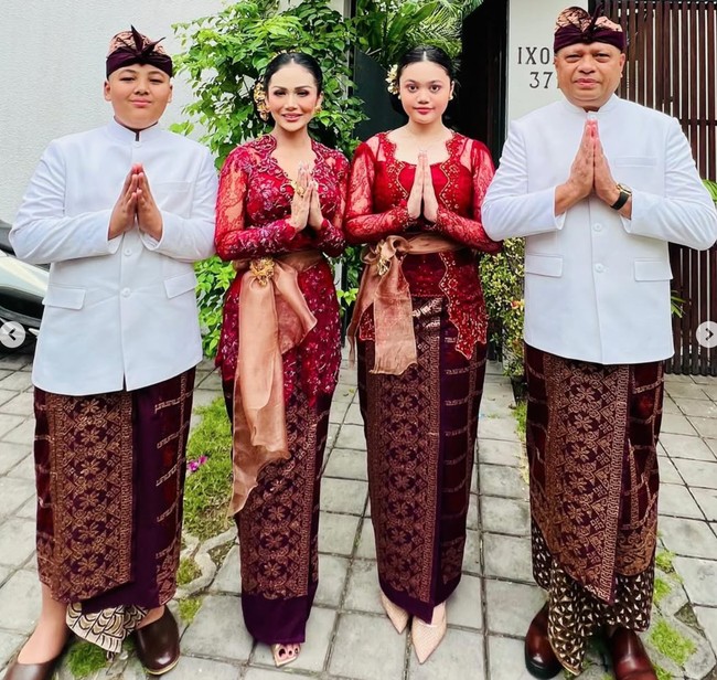 Senada dengan sang mama, Amora mengenakan kebaya Bali berbahan brukat yang dipadukan dengan ikat pinggang berwarna coklat keemasan. Sementara ayah dan adik Amora tampil dengan baju adat atasan berwarna putih dipadukan bawahan kain coklat keunguan bermotif, lengkap dengan ikat kepala atau udeng. Foto: Instagram/@krisdayantilemos