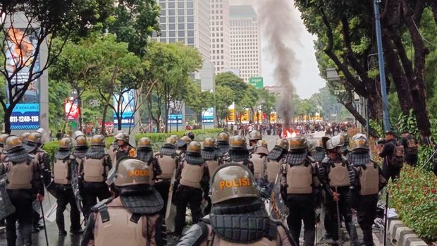 Massa demo yang dibubarkan pihak kepolisian dari gerbang DPR masih bertahan di Jalan Asia Afrika, Senayan, Jakarta, Kamis (28/8/2025). Mereka membakar spanduk hingga water barrier.