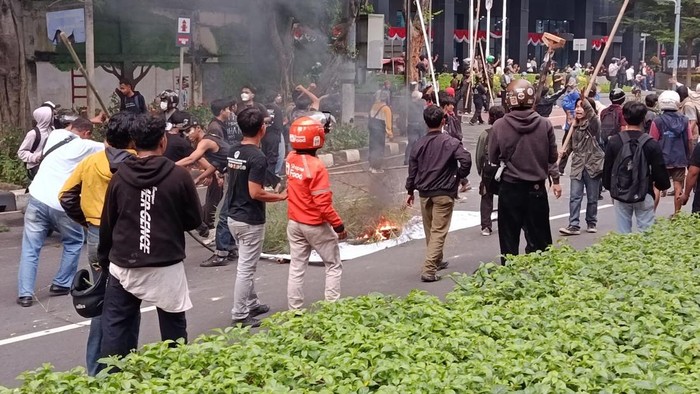 Massa demo yang dibubarkan pihak kepolisian dari gerbang DPR masih bertahan di Jalan Asia Afrika, Senayan, Jakarta, Kamis (28/8/2025). Mereka membakar spanduk hingga water barrier.