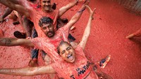 Jalanan kota Bunol berubah jadi lautan bubur tomat merah usai ribuan peserta berpesta dalam tradisi La Tomatina. Foto: REUTERS/Eva Manez