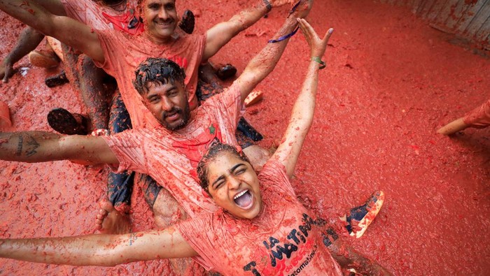 Perang Tomat Terbesar Dunia Warnai Jalanan Spanyol Participants attend the annual 'La Tomatina' food fight festival in Bunol, near Valencia, Spain, August 27, 2025. REUTERS/Eva Manez