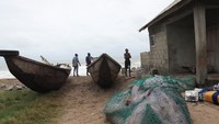Perahu nelayan terseret ombak di pesisir Lagos. Gelombang tinggi membuat nelayan kehilangan sumber mata pencaharian utama mereka. Foto: REUTERS/Sodiq Adelakun