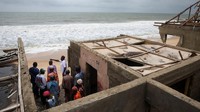 Pada suatu pagi di bulan Juni, gelombang laut melanda desa Apakin, salah satu komunitas pesisir adat terakhir di Lagos, menghanyutkan perahu nelayan, jaring, dan kuburan. Peristiwa ini merupakan peristiwa terbaru dalam permukiman sekitar 3.000 orang yang kehilangan rumah dan mata pencaharian akibat naiknya permukaan laut. Foto: REUTERS/Sodiq Adelakun