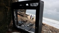 Warga desa Apakin menatap laut yang terus menggerus garis pantai Lagos. Erosi parah mengancam ribuan penduduk pesisir Nigeria. Foto: REUTERS/Sodiq Adelakun
