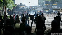 Massa dengan pakaian bebas melempari polisi menggunakan batu. Lemparan terjadi bertubi-tubi sehingga aparat berada dalam posisi terdesak. 