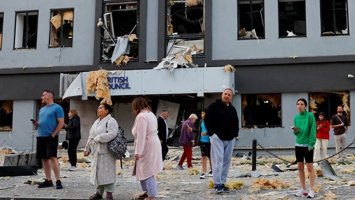 Serangan Udara Rusia Rusak Fasilitas Pendidikan di Ukraina People stand at the site of a building housing the local branch of the British Council after it was hit during Russian missile and drone strikes, amid Russia's attack on Ukraine, in Kyiv, Ukraine, August 28, 2025. REUTERS/Alina Smutko