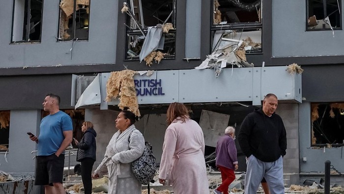 People stand at the site of a building housing the local branch of the British Council after it was hit during Russian missile and drone strikes, amid Russias attack on Ukraine, in Kyiv, Ukraine, August 28, 2025. REUTERS/Alina Smutko