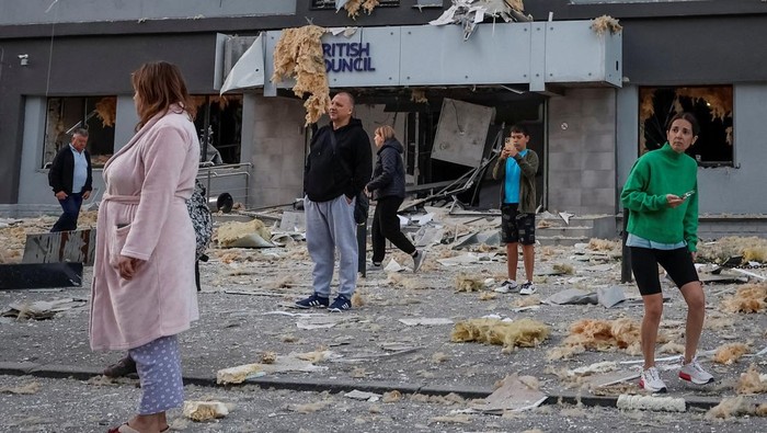 People stand at the site of a building housing the local branch of the British Council after it was hit during Russian missile and drone strikes, amid Russias attack on Ukraine, in Kyiv, Ukraine, August 28, 2025. REUTERS/Alina Smutko