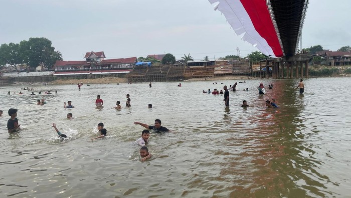 Warga berenang di Sungai Kuantan yang sudah jernih, Kamis (28/8/2025).