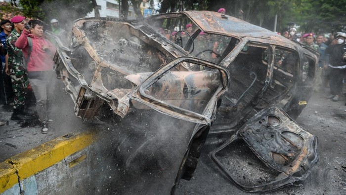 Aksi tuntut pengusutan penabrakan pengemudi ojek online Warga mengambil pintu bangkai mobil yang hangus terbakar saat aksi menuntut pengusutan kasus penabrakan pengemudi ojek online oleh mobil rantis Brimob di Kwitang, Jakarta, Jumat (29/8/2025). ANTARA FOTO/Putra M. Akbar/nz