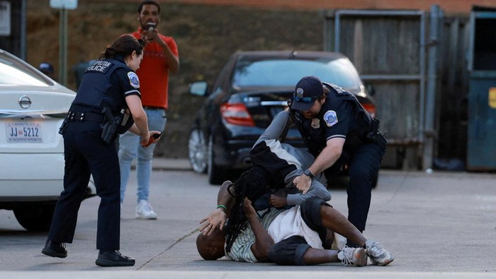 Cegah Kejahatan, Polisi Washington Tertibkan Perkelahian di Tengah Patroli Polisi Metropolitan menahan seorang pria setelah terlibat perkelahian dengan seorang lainnya di kawasan Columbia Heights, Washington, D.C., Amerika Serikat. Insiden itu terjadi ketika aparat tengah melakukan patroli penegakan hukum, beberapa minggu setelah Presiden AS Donald Trump memerintahkan Garda Nasional dan kepolisian memperketat pengawasan di ibu kota negara. REUTERS/Jose Luis Gonzalez