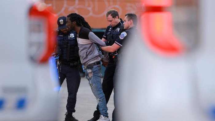 Cegah Kejahatan, Polisi Washington Tertibkan Perkelahian di Tengah Patroli Polisi Metropolitan menahan seorang pria setelah terlibat perkelahian dengan seorang lainnya di kawasan Columbia Heights, Washington, D.C., Amerika Serikat. Insiden itu terjadi ketika aparat tengah melakukan patroli penegakan hukum, beberapa minggu setelah Presiden AS Donald Trump memerintahkan Garda Nasional dan kepolisian memperketat pengawasan di ibu kota negara. REUTERS/Jose Luis Gonzalez