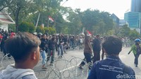 Setibanya di depan Grahadi sekitar pukul 14.45 WIB, sejumlah massa mencoba menerobos gerbang utama hingga melemparkan batu dan botol air mineral ke arah pintu masuk gedung.