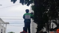 Para driver Ojol terlihat membagikan makanan ke para mahasiswa. Kemudian salah satu driver Ojol terlihat naik ke mobil komando aksi dan memperlihatkan tulisan jangan lindas kami. (Foto: Nizar Aldi/detikSumut)