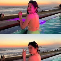 Aura bahagia terpancar dari wajahnya saat berenang di salah satu beach club populer, yang menghadap ke pantai dan menyuguhkan pemandangan sunset. Foto: dok. Instagram @j_chaeyeoni