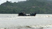 Dengan menggunakan tali milik nelayan setempat satu per satu ABK yang telah dilengkapi jaket pelampung merayap dari atas kapal menju ke bibir pantai.