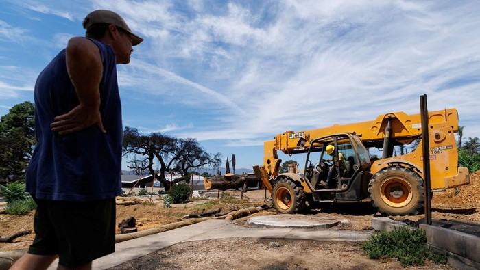Kayu Sisa Kebakaran Hutan Los Angeles Disulap untuk Bangun Kembali Rumah Warga A drone view shows Jeff Perry, founder of Angel City Lumber, as he drives away in his mechanized tractor to collect trees lost to the Eaton Fire, in Altadena, California, U.S., August 21, 2025. Perry is helping residents rebuild their homes with wood from trees damaged in the fire. REUTERS/Mike Blake