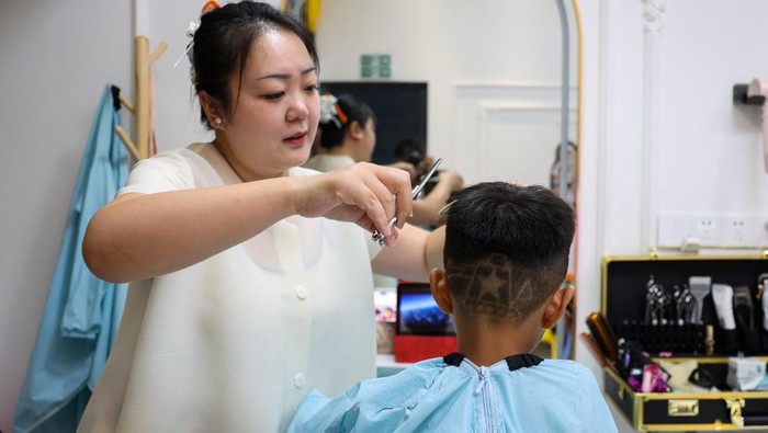 Cara unik dilakukan seorang pemilik salon rambut di Beijing untuk memperingati 80 tahun berakhirnya Perang Dunia Kedua. Wang Xueru, pemilik salon sederhana di ibu kota Tiongkok itu, menghadirkan potongan rambut bernuansa patriotik yang mencuri perhatian publik. REUTERS/Tingshu Wang