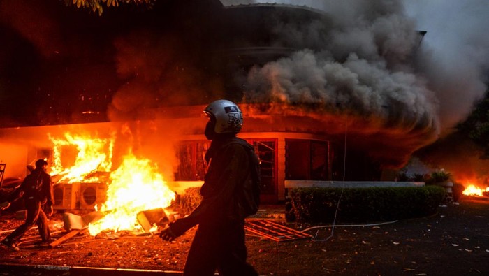 Massa aksi bakar Mess MPR di Bandung Seorang pengemudi ojek online mengambil gambar Mess MPR RI yang dibakar di Bandung, Jawa Barat, Jumat (29/8/2025). Mess MPR RI dibakar oleh massa aksi yang menuntut pembatalan kenaikan tunjangan Anggota DPR RI serta pengusutan penabrakan pengemudi ojek online. ANTARA FOTO/Raisan Al Farisi/rwa.