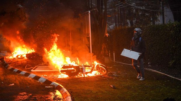 Seorang pengemudi ojek online mengambil gambar Mess MPR RI yang dibakar di Bandung, Jawa Barat, Jumat (29/8/2025). Mess MPR RI dibakar oleh massa aksi yang menuntut pembatalan kenaikan tunjangan Anggota DPR RI serta pengusutan penabrakan pengemudi ojek online. ANTARA FOTO/Raisan Al Farisi/rwa.